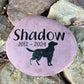 Pink stone with 'Shadow' and a dog silhouette engraved, set against a natural stone background.
